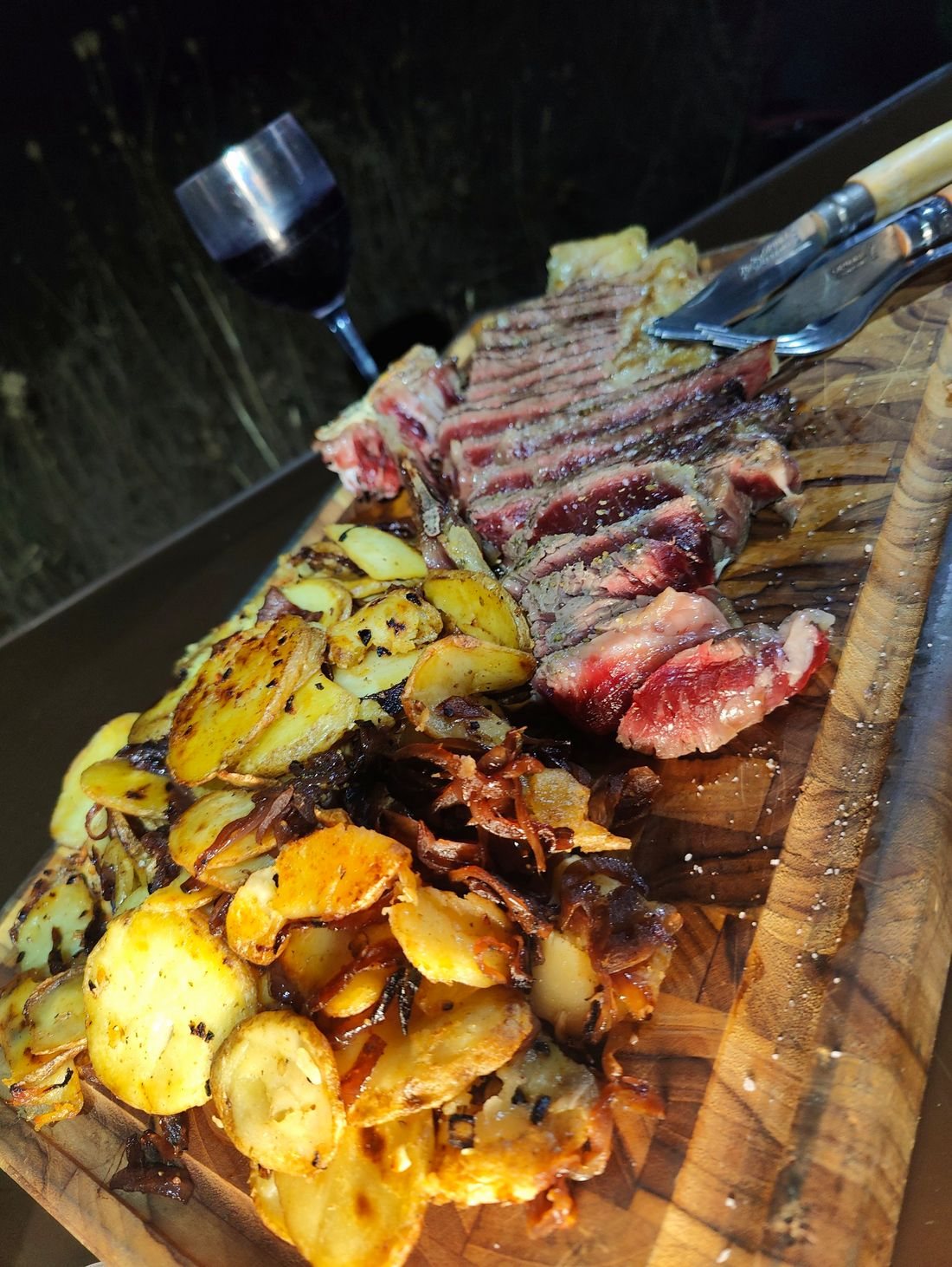 Repas grillé partagé au bivouac, verre de vin