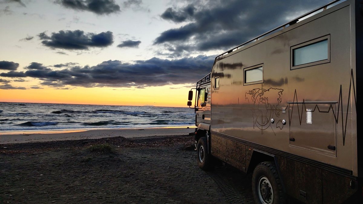 Camion d'expédition sur une plage au coucher du soleil