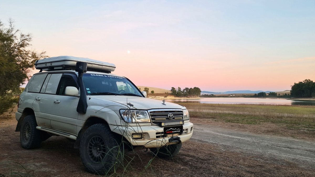 4x4 de voyage au bord d'un lac au crépuscule