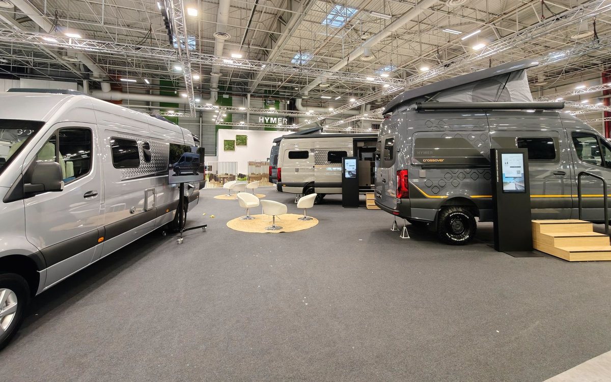 Allée d'un salon du camping-car, fourgons aménagés exposés